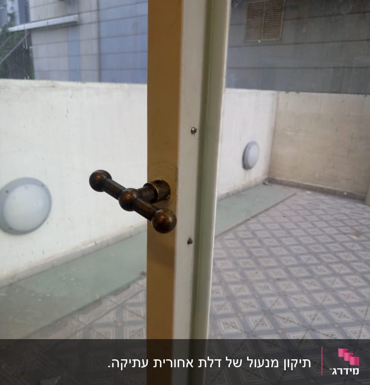 ידית דלת מתכתית על דלת זכוכית